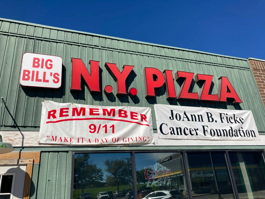 In preparation for Big Bill's New York Pizza's Day of Giving on September 11th, the restaurant hung up signs on the side of their restaurant in remembrance of the September 11 attacks and for the nonprofit founded by the owner, Bill Ficke.